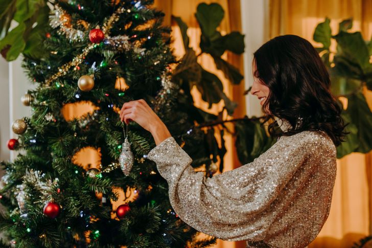 Vrouw is een Kerstboom aan het Versieren